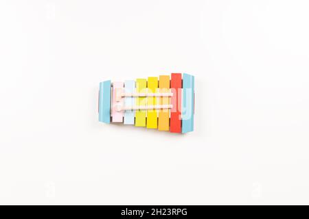 Draufsicht auf buntes Holz-Xylophon mit Stöcken auf weißem Hintergrund. Frühe Bildung für Kinder. Musik für Kinder lernen. Pädagogische Montessori Stockfoto