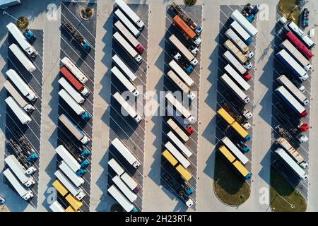 Parkplatz für Sattelschlepper, Draufsicht. Luftaufnahme von LKW-Anhängern, die für die wartende Beladung im Werk geparkt sind. Logistik und Versand Stockfoto