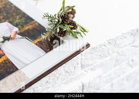 Luxus Holz Fotobuch, Holzkiste mit Sommerfotos gedruckt und Flash-Karte auf Leinen natürlichen Hintergrund. Fotobuch für Familienerinnerungen. Speichern Sie Ihr Stockfoto