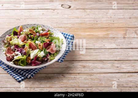 Feigen-Salat mit Käse und Walnüssen auf Holztisch. Stockfoto