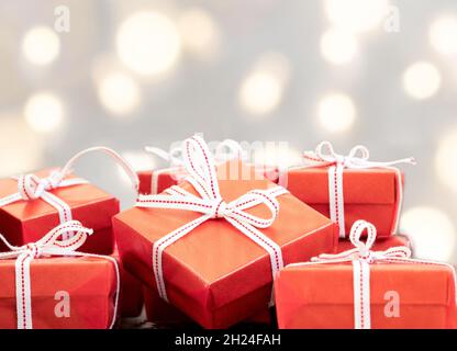 Nahaufnahme von roten Geschenkschachteln und kreisförmigen Bokehs. Liebe, Geschenk und gegenwärtiges Konzept. Stockfoto