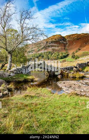 Wunderschöne, malerische Slater's Bridge, eine Fußgängerbrücke aus dem 17. Jahrhundert über den Fluss Brathay bei Little Langdale, Lake District National Park, Cumbria Stockfoto