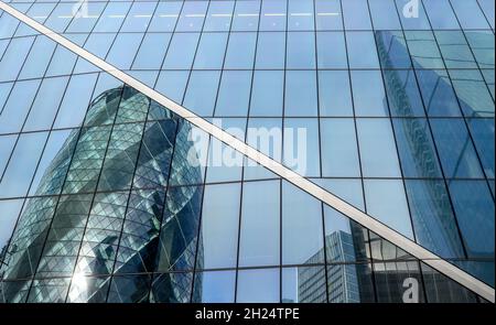 Die Gebäude von Gherkin und Cheesegrater spiegeln sich in der Glasfassade des Skalpell-Gebäudes in der City of London, England. Stockfoto