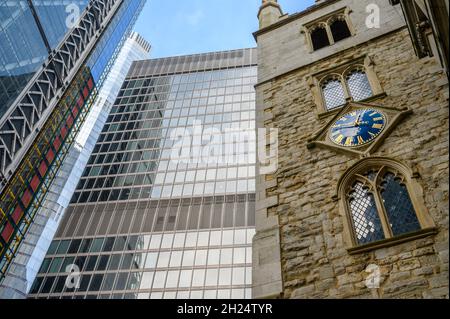 Alt und neu: Die St. Andrew Undershaft Church aus dem 15. Jahrhundert neben den Wolkenkratzern St. Helen's und Cheesegrater; City of London, England. Stockfoto