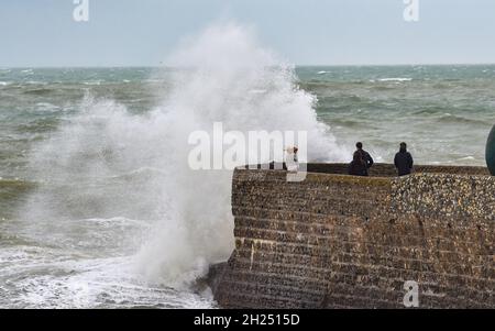 Brighton UK 20. Oktober 2021 - die Besucher werden von den Wellen am Strand und am Strand von Brighton durchnässt, wenn heute Regen und starke Winde über Großbritannien ziehen. : Credit Simon Dack / Alamy Live News Stockfoto