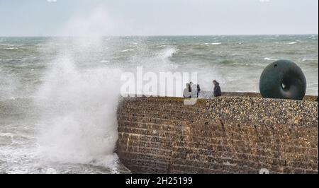 Brighton UK 20. Oktober 2021 - die Besucher werden von den Wellen am Strand und am Strand von Brighton durchnässt, wenn heute Regen und starke Winde über Großbritannien ziehen. : Credit Simon Dack / Alamy Live News Stockfoto