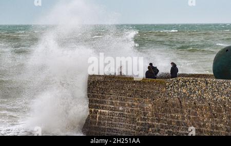 Brighton UK 20. Oktober 2021 - die Besucher werden von den Wellen am Strand und am Strand von Brighton durchnässt, wenn heute Regen und starke Winde über Großbritannien ziehen. : Credit Simon Dack / Alamy Live News Stockfoto