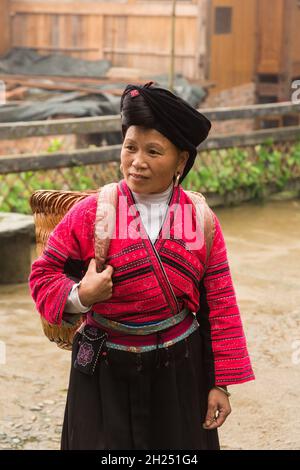 Eine Frau der ethnischen Minderheit der Roten Yao in traditioneller Kleidung auf den Jinkeng-Reisterrassen, Longshen, China. Stockfoto
