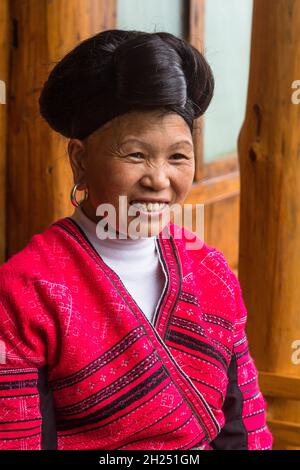 Eine Frau der ethnischen Minderheit der Roten Yao in traditioneller Kleidung auf den Jinkeng-Reisterrassen, Longshen, China. Stockfoto