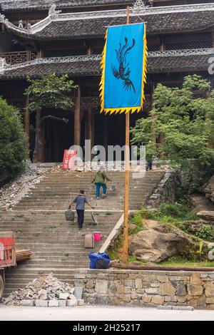 Arbeiter, die Eimer auf Jochen tragen, um Schutt aus einem Gebäude zu entfernen, das in Furong, China, renoviert wird. Stockfoto