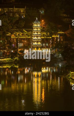 Die Wanming-Pagode spiegelte sich in der Nacht im Fluss Tuojiang, Fenghuang, China, wider. Stockfoto