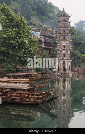 Die Wanming-Pagode und Ausflugsboote auf dem Tuojiang-Fluss in Fenghuang, China. Stockfoto