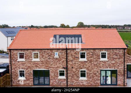 SKIPWITH, GROSSBRITANNIEN - 20. OKTOBER 2021. Ein Neubau mit eingebauten Photovoltaik-Solarzellen im Dach, die saubere und erneuerbare Energie für Häuser erzeugen Stockfoto