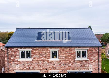 SKIPWITH, GROSSBRITANNIEN - 20. OKTOBER 2021. Ein Neubau mit eingebauten Photovoltaik-Solarzellen im Dach, die saubere und erneuerbare Energie für Häuser erzeugen Stockfoto