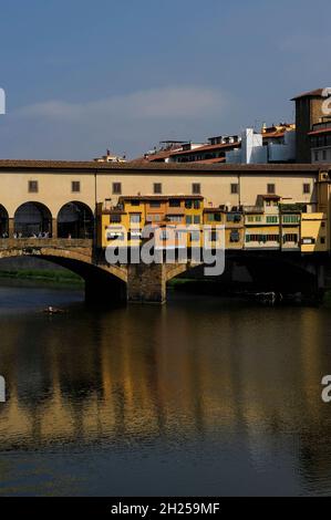 Ein einziger Ruderer unter einer mittelalterlichen Brücke über den Fluss Arno - der Ponte Vecchio in Florenz, Toskana, Italien Stockfoto