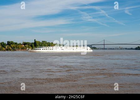 Ein Kreuzfahrtschiff, das den Fluss Garonne bei Bordeaux, einem großen Kreuzfahrthafen in Südfrankreich, plissiert Stockfoto