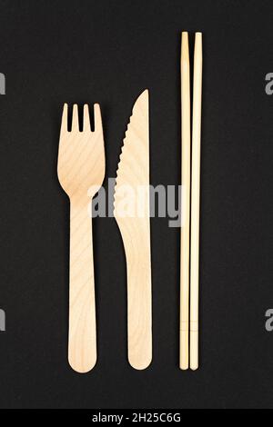 Vertikales Foto. Einweggeschirr aus natürlichen Materialien, Messer, Holzgabel, Sushi-Sticks, umweltfreundlich. Stockfoto