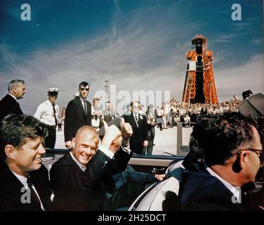 CAPE CANAVERAL Florida -- Astronaut John H. Glenn Jr. zeigt sich doppelt begeistert, als er und Präsident John F. Kennedy im Cape Canaveral Missile Test Annex in Florida eintreffen. Glenn's Mercury Atlas 6 Mission hob am 20. Februar 1962 vom Launch Complex 14 im Hintergrund ab. Stockfoto