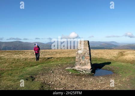 Walker nähert sich dem Ordnance Survey Triangulation Point auf dem Gipfel des Loadpot Hill, Lake District, Cumbria, Großbritannien Stockfoto