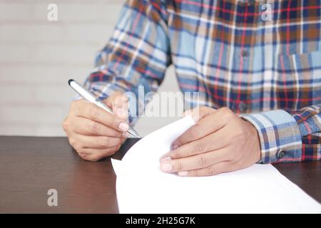 Mann Hand in Brunnen Stift schreiben oder Unterschrift auf Papier. Stockfoto