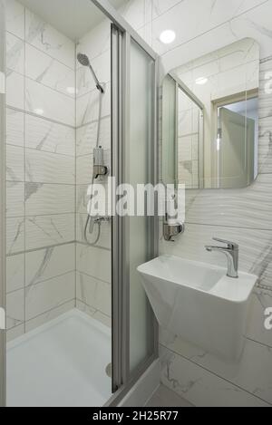 Die Inneneinrichtung des hellen und modernen weißen Badezimmers. Duschkabine Stockfoto