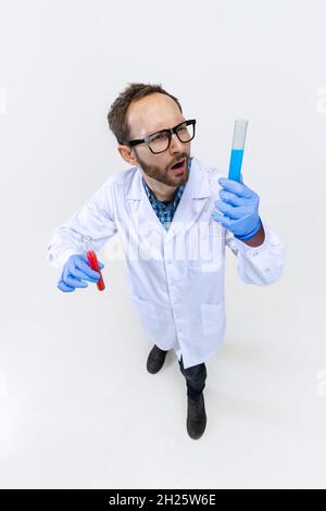 Aus der Perspektive eines jungen Chemikers führt der Arzt auf weißem Hintergrund isolierte chemische Forschungen durch. Konzept der Pharmakologie. Stockfoto
