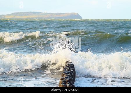 Insel Hiddensee von Rügen aus gesehen mit niedrigen Wellen, die über einem Wellenbrecher plätschern. Stockfoto