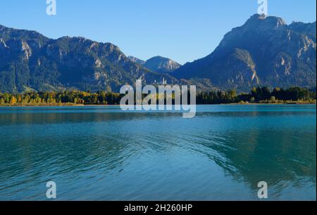 Malerische Alpenlandschaft mit Forggensee umgeben von den deutschen Alpen und Schloss Neuschwanstein in der Ferne (Füssen in Bayern) Stockfoto