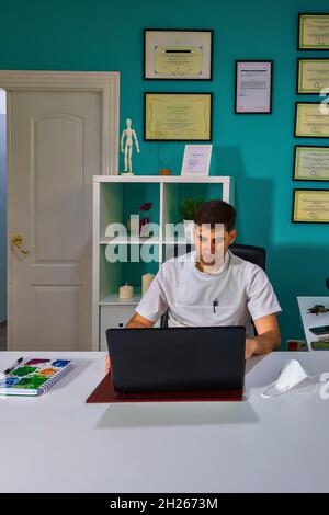 Arzt, der in einem Büro arbeitet, mit einem Laptop. Stockfoto