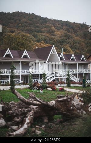 Gemütliche hölzerne Herrenhäuser in Bergdorf. Wunderschöne Ferienhäuser in den Bergen. Herbstlaub auf Bäumen. Gemütlichkeit und Komfort Konzept Stockfoto