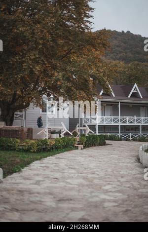 Gemütliche hölzerne Herrenhäuser in Bergdorf. Wunderschöne Ferienhäuser in den Bergen. Herbstlaub auf Bäumen. Gemütlichkeit und Komfort Konzept Stockfoto