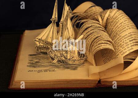 Buchskulptur aus einer alten illustrierten Ausgabe von Treasure Island von Robert Louis Stevenson. Buch geschnitten, um Welle über Schiff krachen zu lassen Stockfoto