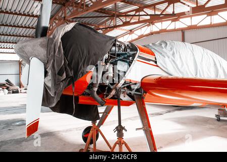 Ultraleichtes kleines Privatflugzeug, das im Hangar am Flughafen repariert wird Stockfoto