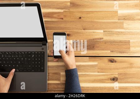 Mann mit Laptop und Smartphone. Bildschirmmockup Stockfoto