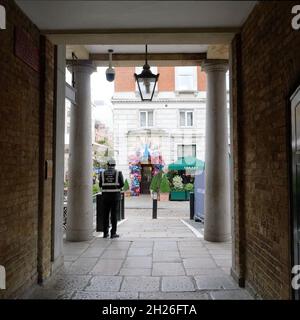 London, Greater London, England, Oktober 05 2021: Ein Mitglied des Sicherheitsstabs von Covent Garden wartet neben der Henrietta Street gegenüber dem Ivy Market GRI Stockfoto