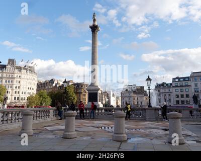 London, Greater London, England, Oktober 05 2021: Die Nelsons-Säule steht hoch auf dem Trafalgar Square, während Touristen eine erhöhte Aussicht genießen. Stockfoto