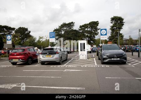 Elektrofahrzeuge laden in speziellen Charhing-Bereich bei VW EV Ladegeräten Tesco Store Parkplatz Churchdown UK Stockfoto