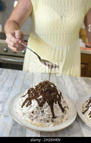 Ein Schritt-für-Schritt-Prozess für die Herstellung einer sauren Sahneschokolade Kuchen. Der geformte Kuchen wird mit flüssigem Schokoladeneier gegossen. Stockfoto