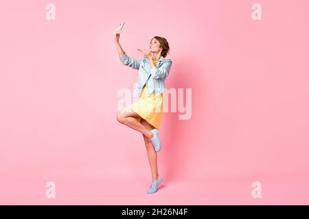 In voller Größe Profil Foto von optimistisch schöne Brünette Dame Schlag Kuss tragen Jacke Kleid isoliert auf rosa Hintergrund Stockfoto