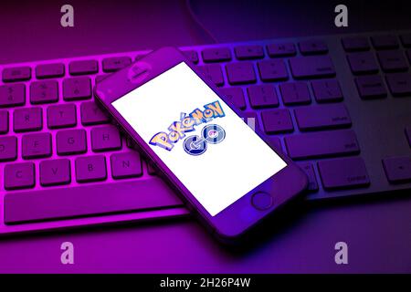 In dieser Abbildung ist ein Pokemon GO-Logo zu sehen, das auf einem Smartphone auf einer Computertastatur angezeigt wird. Stockfoto