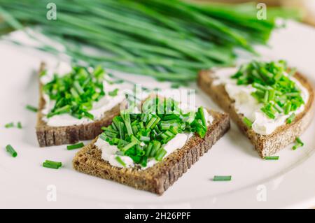 Roggenbrot-Sandwiches mit frischem Käse und grünen Zwiebeln Stockfoto