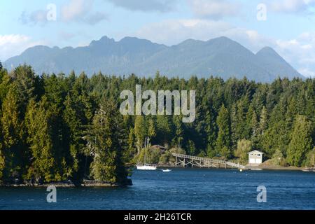 Die Ufer von Stone Island und die weit entfernten Peals des Clayoquot Sound, in der Nähe von Tofino, Vancouver Island, British Columbia, Kanada. Stockfoto