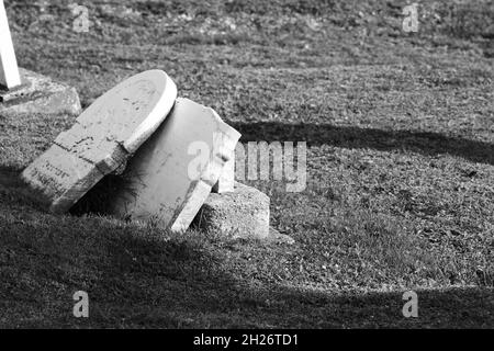 Gebrochene Grabsteine auf einem alten, stillgelegt Friedhof Stockfoto