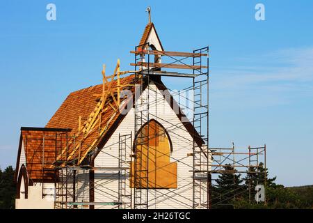 Eine alte Kirche, um die herum ein Gerüst errichtet wurde, wird renoviert. Stockfoto