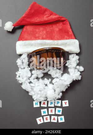 Roter Samthut mit Schneemaske und Baumwoll-Schnurrbart und Bart. Neujahrskarte Stockfoto