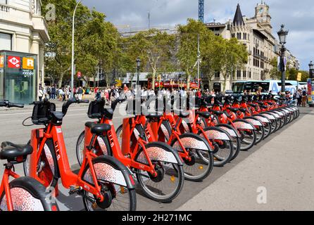 Bike-Sharing Station - Eine lange Reihe brandneuer Fahrräder, die an einer Bike-Sharing-Station am nördlichen Rand der Plaza de Catalunya im Zentrum von Barcelona parken. Stockfoto