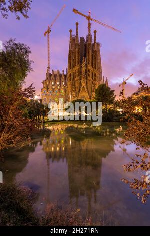 Sagrada Familia - Eine vertikale Sonnenuntergangsansicht der östlichen Krippe façade von Basílica de la Sagrada Família, die sich in einem kleinen Teich widerspiegelt. Barcelona, Spanien. Stockfoto