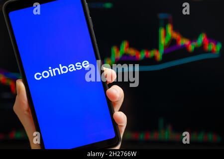 Ukraine, Odessa - Oktober, 9 2021: Coinbase mobile App läuft auf dem Smartphone-Bildschirm mit Trading Candlestick Chart im Hintergrund. Coinbase ist Amerikaner Stockfoto