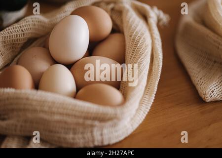 Eier in Leinenlebensmittelbeutel. Eier von Öko-Farm. Baumwollbeutel auf Holztisch. Zero Waste Shopping-Konzept. Kunststoffartikel Stockfoto