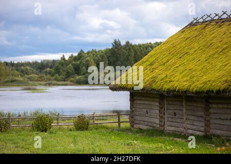 Ländliche russische Landschaft mit einem alten Holzhaus an einer Seenküste Stockfoto